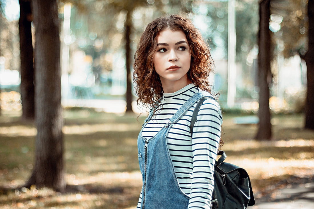 Young lady wearing a denim jumper.