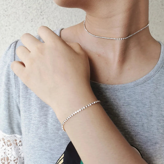 Picture of a woman wearing a matching necklace and bracelet.